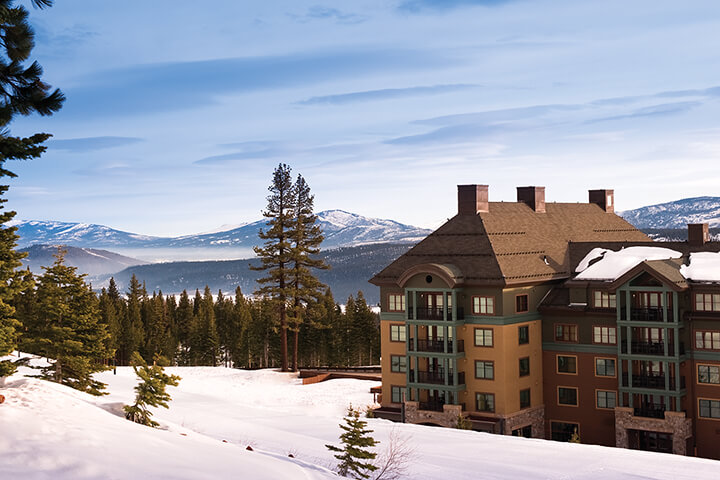Ritz Carlton Club, Lake Tahoe exterior view of the resort with snow-capped mountains and snow covered ground